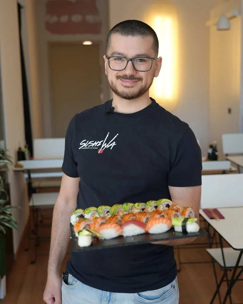 Le fondateur de Sushi Wa en salle, un plateau de sushis à la main, Place Eugène Flagey à Ixelles